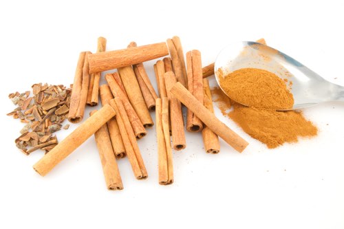 Paus de canela e canela em pó numa colher